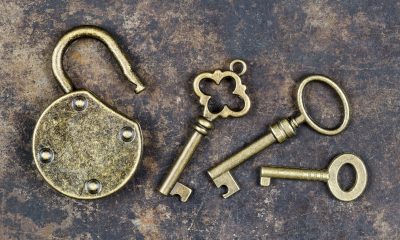 Antique keys and padlock on a rusty metal background